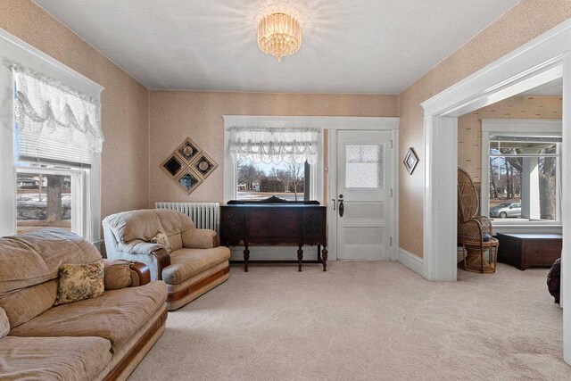 living area with radiator, wallpapered walls, and carpet floors