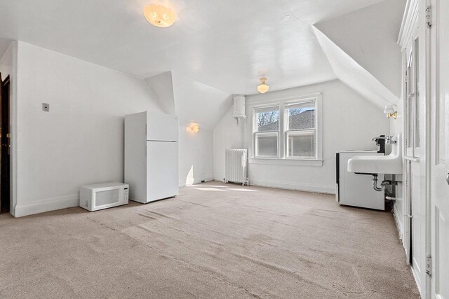 bonus room featuring radiator heating unit, vaulted ceiling, and carpet flooring