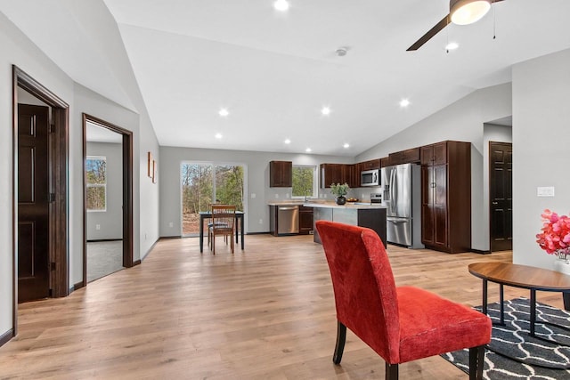 living room featuring light wood-type flooring, baseboards, vaulted ceiling, and recessed lighting