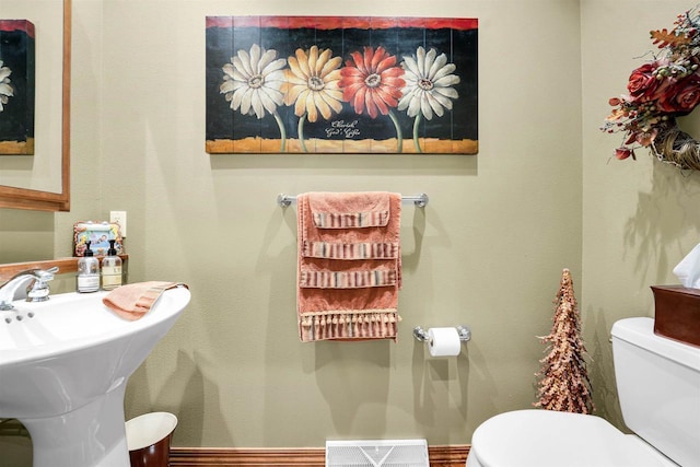 bathroom featuring baseboards, visible vents, a sink, and toilet