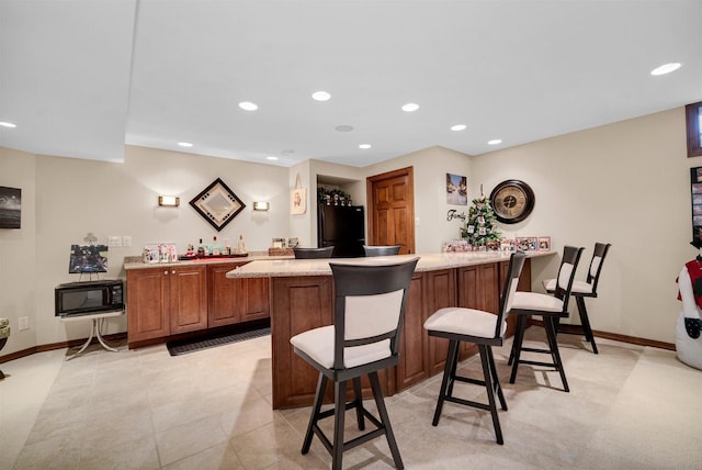 bar featuring black appliances, wet bar, baseboards, and recessed lighting