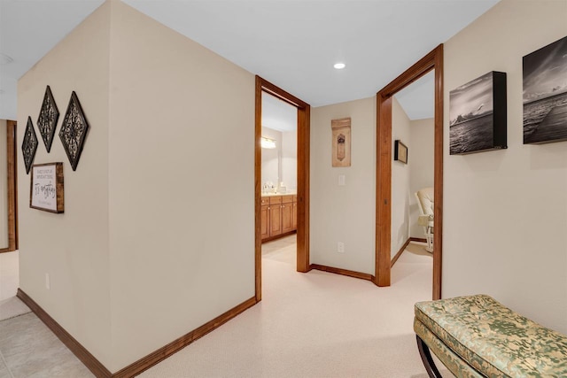 corridor with recessed lighting, light colored carpet, and baseboards