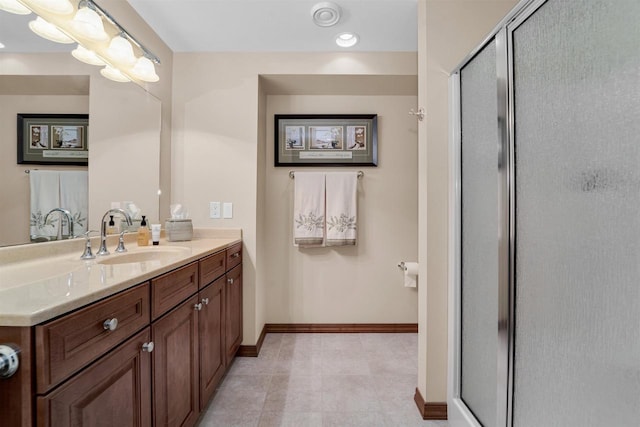 full bathroom with a stall shower, vanity, and baseboards