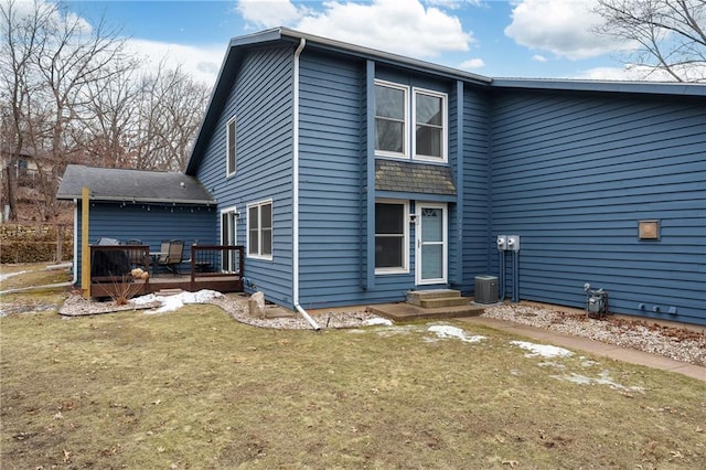 back of property featuring entry steps, a lawn, and a wooden deck