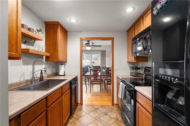 kitchen with brown cabinetry, light countertops, black appliances, open shelves, and a sink