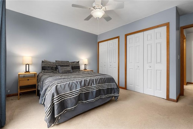 carpeted bedroom with ceiling fan, baseboards, and multiple closets