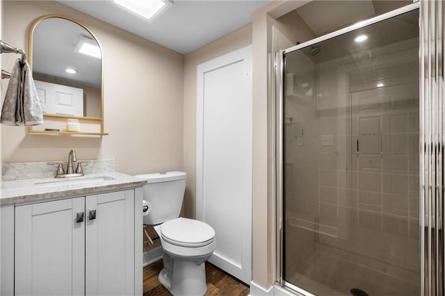 full bathroom with toilet, a stall shower, wood finished floors, and vanity