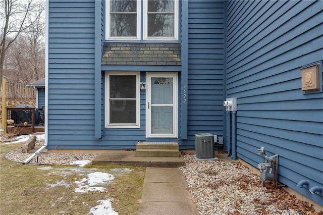 doorway to property with cooling unit and fence