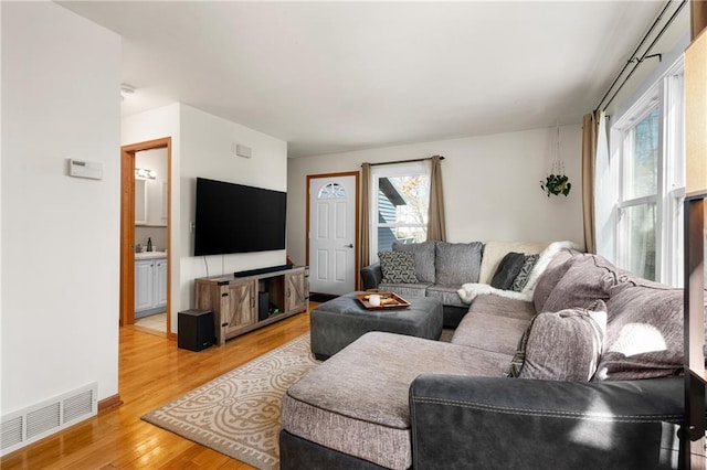 living area with visible vents and light wood finished floors