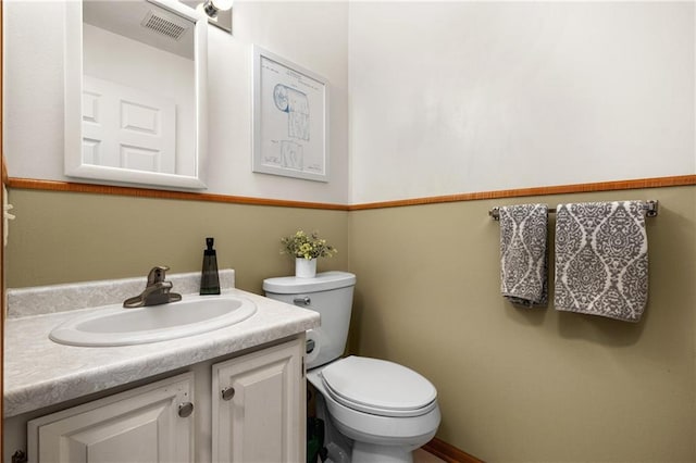 half bathroom with toilet, visible vents, and vanity