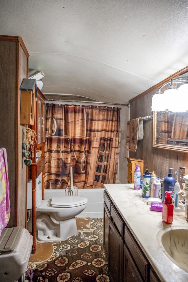 full bath featuring a textured ceiling, toilet, shower / tub combo, wood walls, and vanity