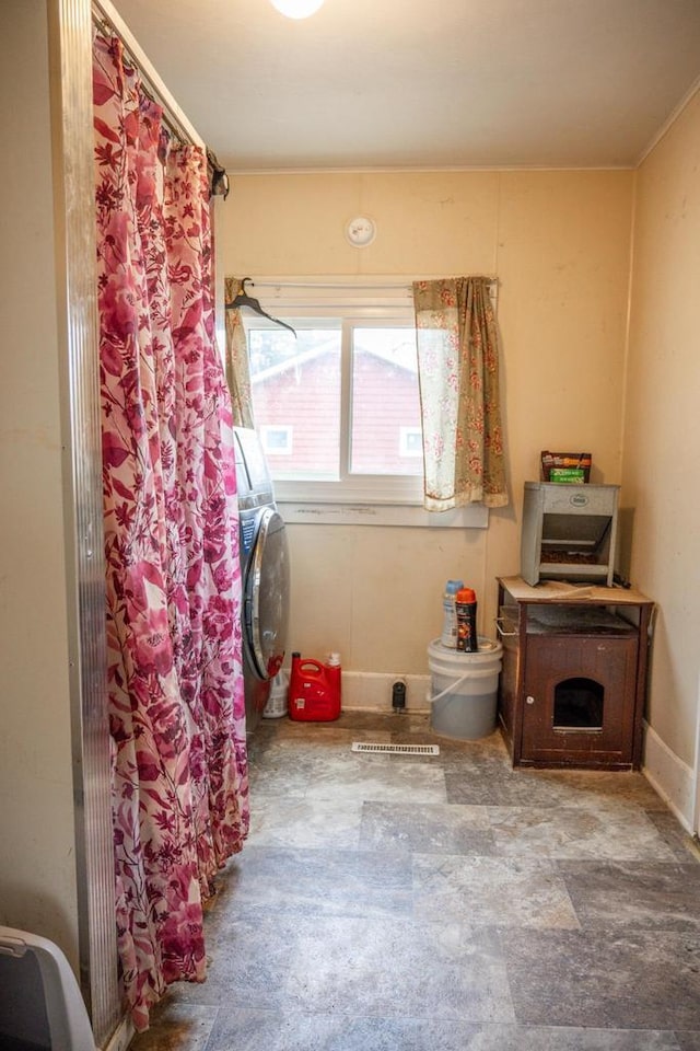 clothes washing area featuring washer / clothes dryer, baseboards, and laundry area