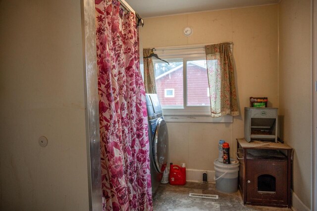 clothes washing area featuring laundry area, washer / dryer, visible vents, and baseboards