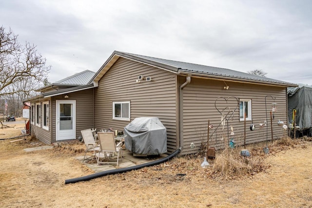 rear view of house featuring metal roof and a patio