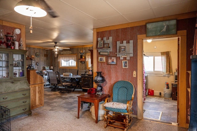 interior space featuring ceiling fan and wooden walls