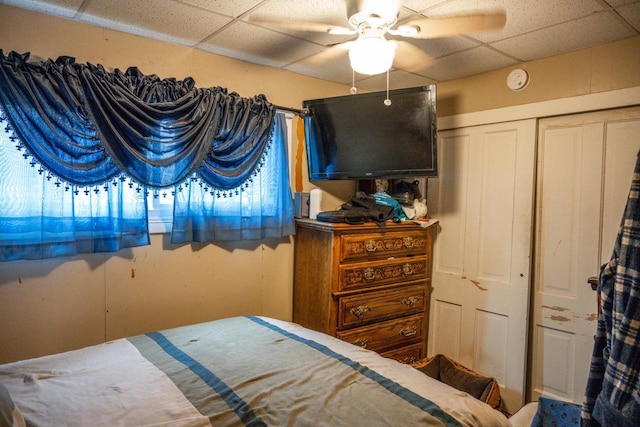 bedroom with ceiling fan and a drop ceiling