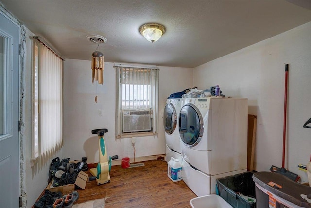 clothes washing area with laundry area, visible vents, wood finished floors, cooling unit, and washing machine and dryer