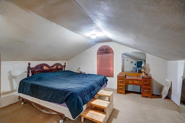 bedroom featuring a textured ceiling, vaulted ceiling, and carpet flooring