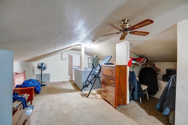 additional living space with ceiling fan, vaulted ceiling, a textured ceiling, and carpet flooring