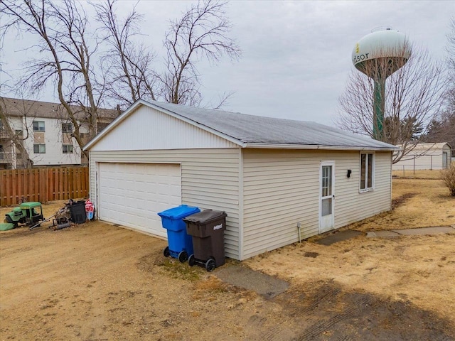 detached garage featuring fence