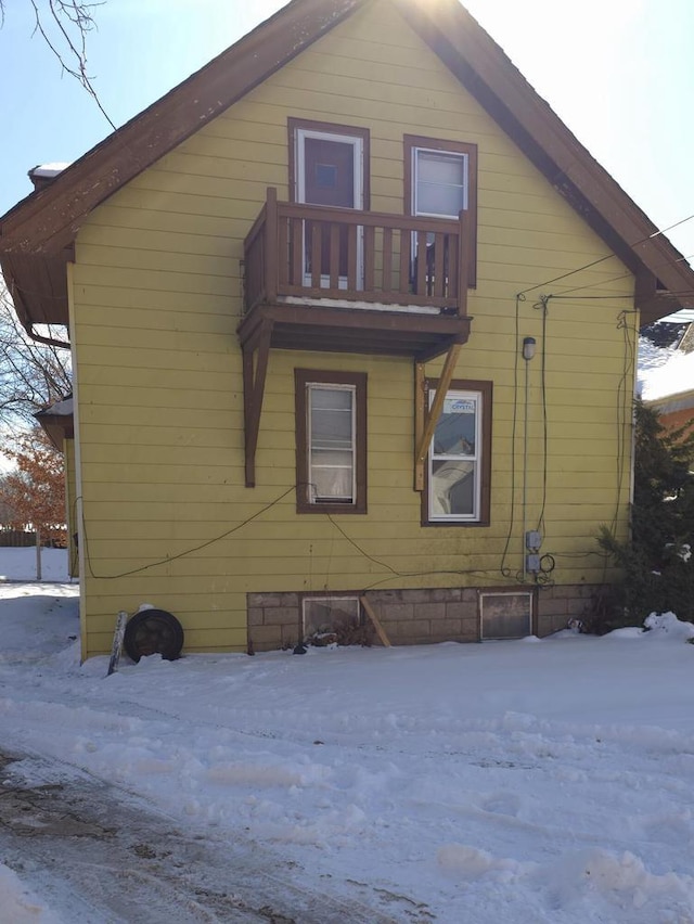 view of snowy exterior featuring a balcony