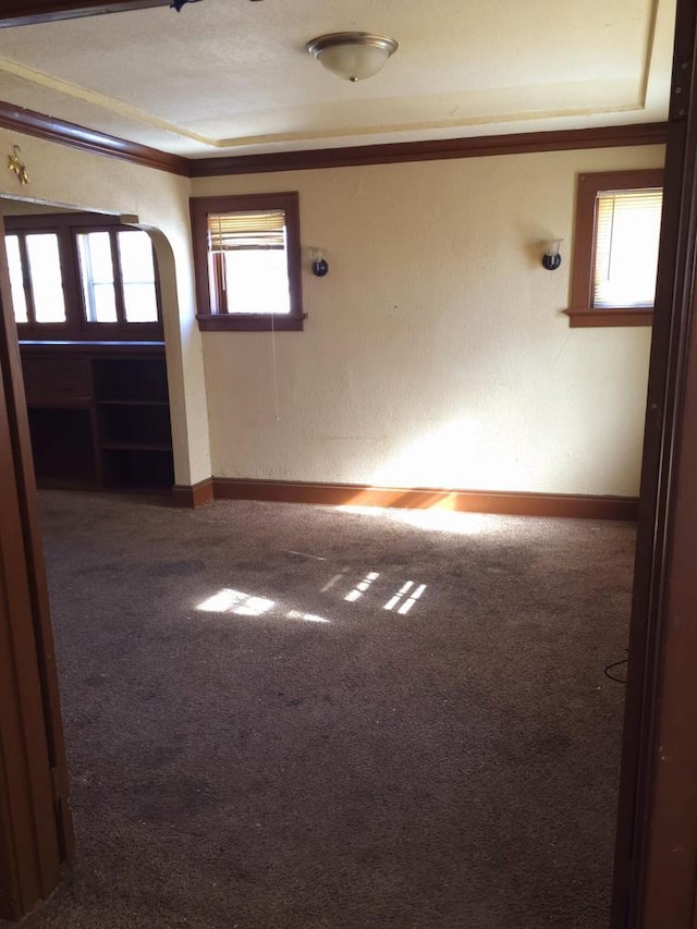 carpeted spare room featuring baseboards