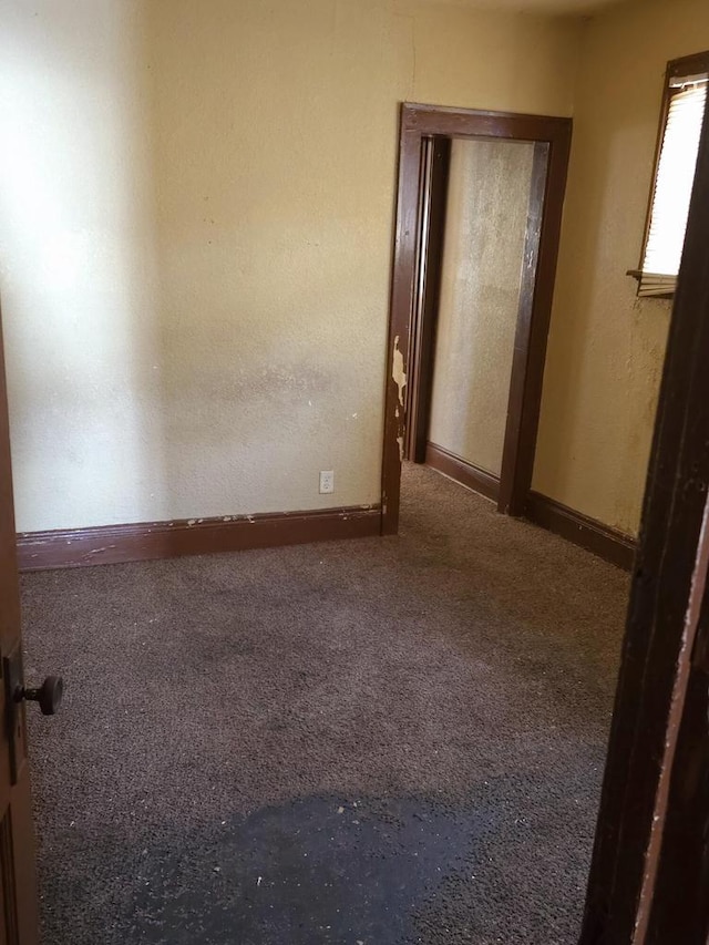 carpeted spare room featuring baseboards