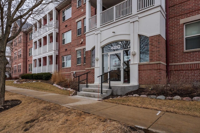 entrance to property featuring brick siding