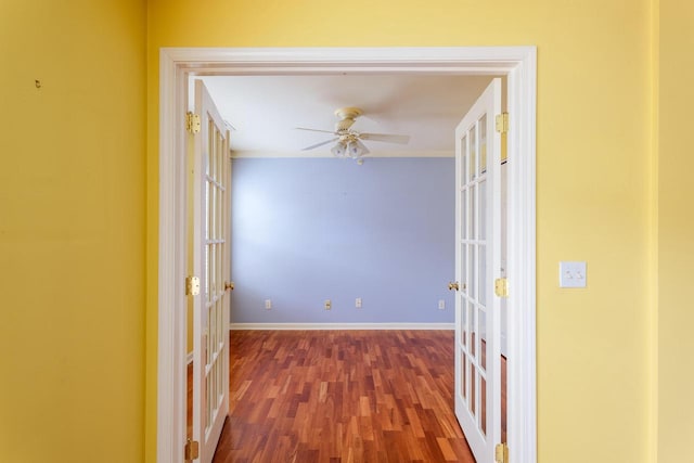 hallway featuring ornamental molding, french doors, baseboards, and wood finished floors