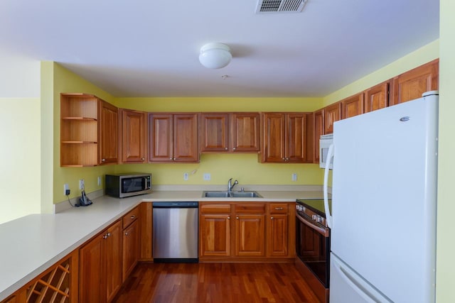 kitchen featuring dark wood-type flooring, a sink, visible vents, appliances with stainless steel finishes, and open shelves