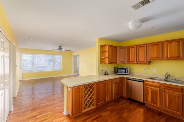 kitchen featuring visible vents, appliances with stainless steel finishes, light countertops, open shelves, and a sink