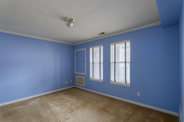 carpeted empty room with baseboards, visible vents, and crown molding