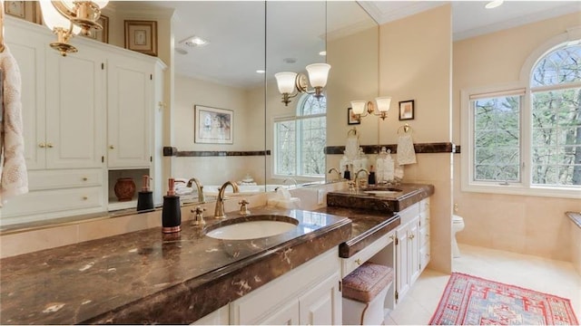 bathroom with a sink, tile walls, and a healthy amount of sunlight