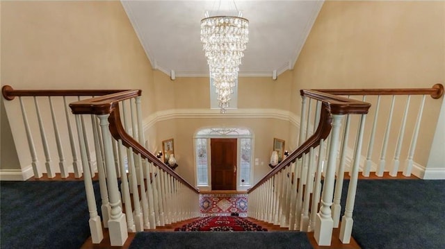 stairs with crown molding, carpet, baseboards, and a chandelier