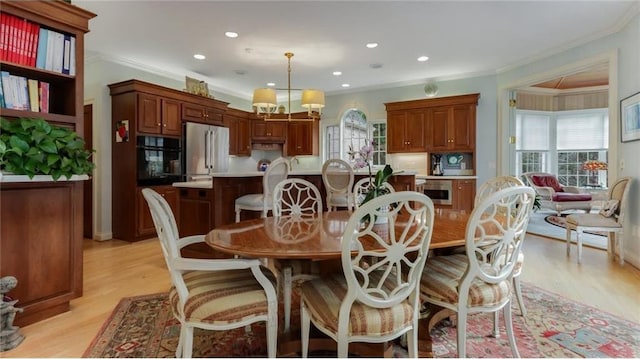 dining area with recessed lighting, light wood-style flooring, crown molding, and an inviting chandelier