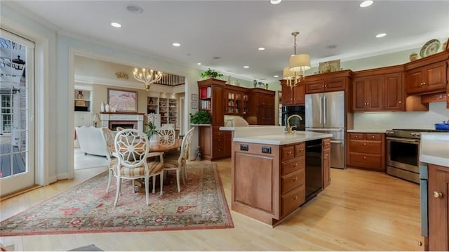 kitchen featuring black appliances, crown molding, light countertops, and a chandelier