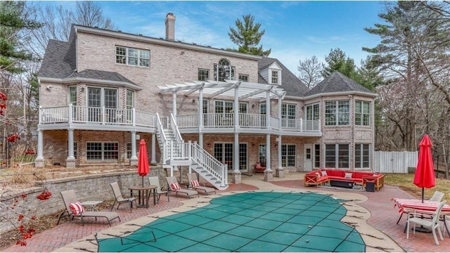 back of property with brick siding, an outdoor living space, stairs, a pergola, and a patio