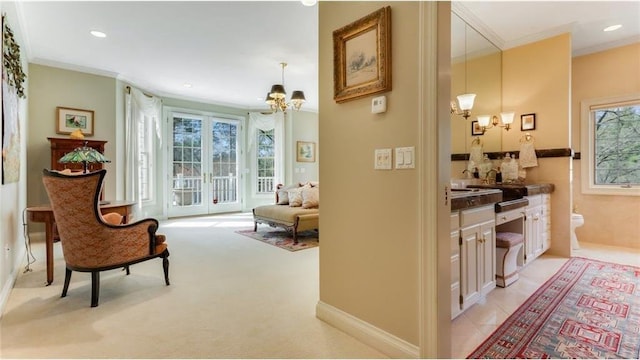 corridor with an inviting chandelier, a healthy amount of sunlight, and ornamental molding