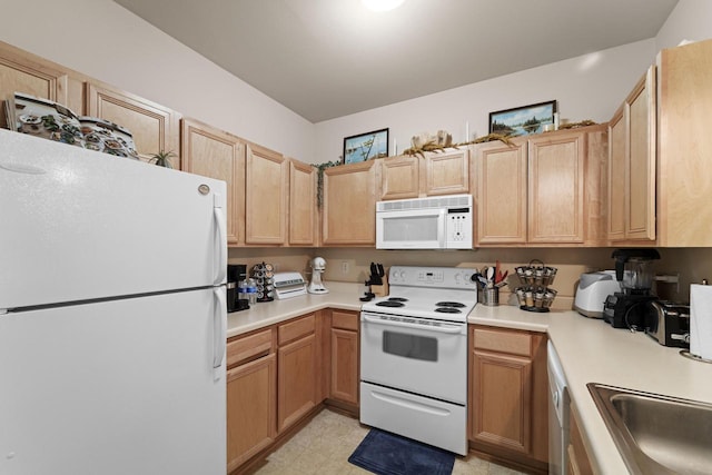 kitchen with white appliances, light countertops, light brown cabinetry, light floors, and a sink