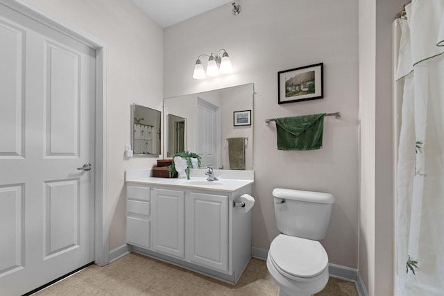 bathroom featuring vanity, toilet, and baseboards