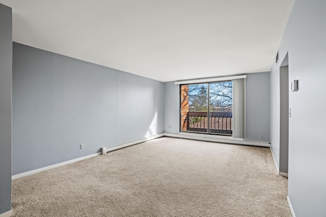 carpeted empty room featuring a baseboard heating unit and baseboards