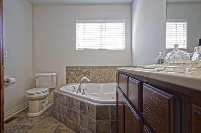 bathroom featuring a wealth of natural light, vanity, toilet, and a bath