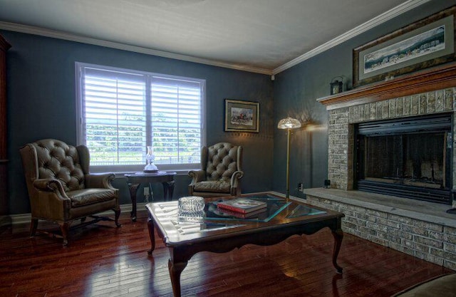 living area with baseboards, hardwood / wood-style floors, a fireplace, and crown molding