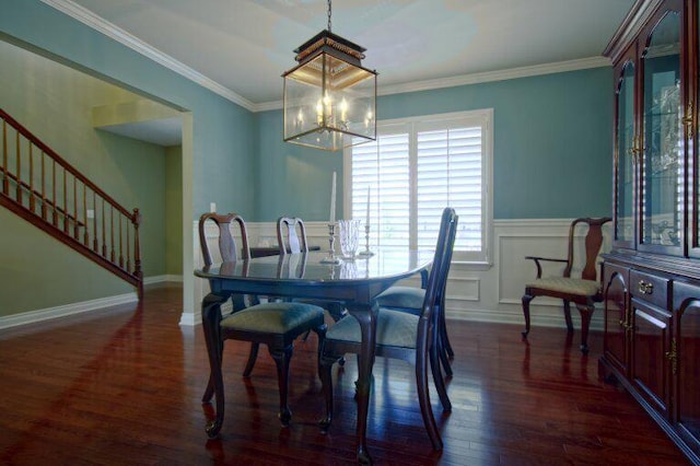 dining room featuring stairway, a decorative wall, wood finished floors, and ornamental molding