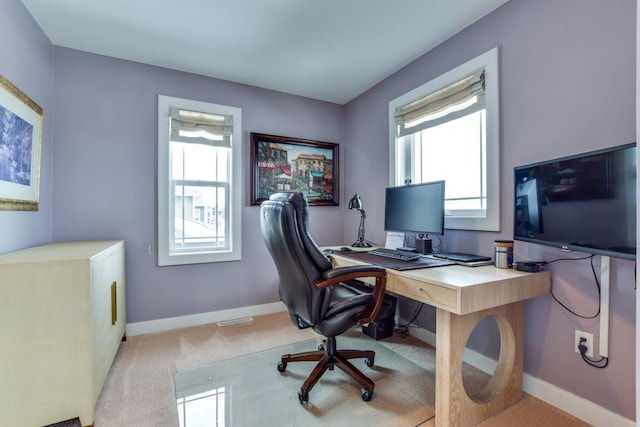 carpeted home office with plenty of natural light and baseboards