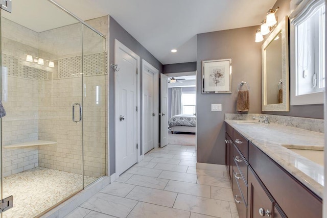 ensuite bathroom featuring marble finish floor, double vanity, a ceiling fan, a stall shower, and baseboards