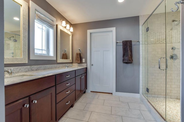 full bath with baseboards, double vanity, a sink, and a shower stall