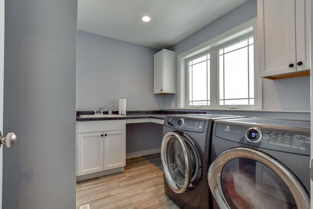 clothes washing area with washing machine and dryer, recessed lighting, a sink, light wood-style floors, and cabinet space