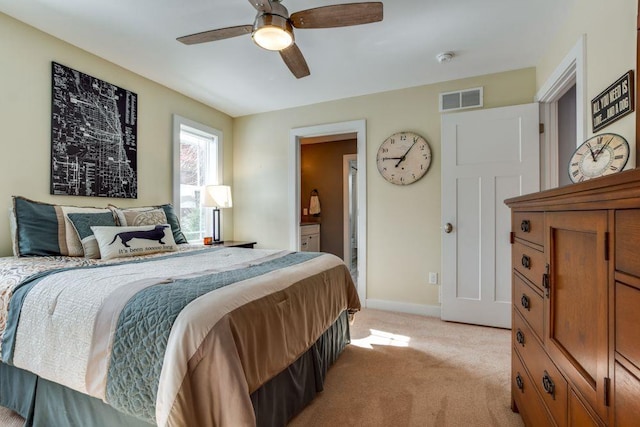 bedroom featuring light carpet, baseboards, visible vents, a ceiling fan, and ensuite bathroom