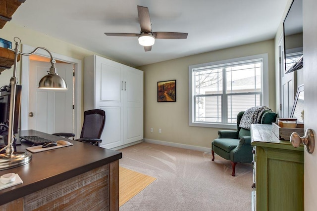 home office with light carpet, ceiling fan, and baseboards